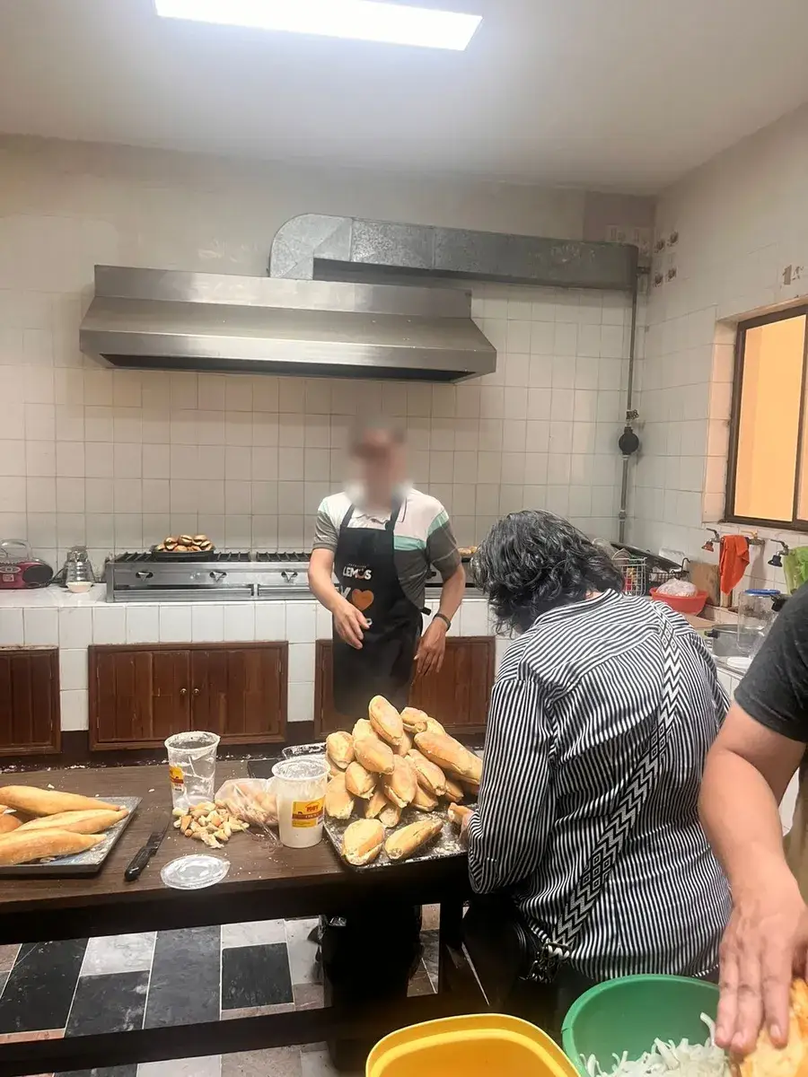 Voluntarios preparando pan en la cocina del comedor